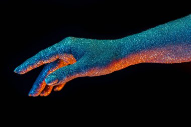 Kadın eli, neon renkli ışığın altında holografik parıltılarla kaplı. Vücut sanatı, görkemli kavramsal, moda tarzı..