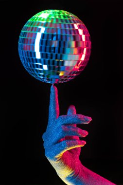 Disko ayna topunu neonun altında tutan kadın. Parlak gümüş küre ışığı yansıtıyor. Retro gece partisi, müzik ve eğlence konsepti geçmişi