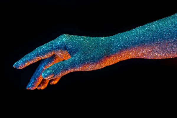 Mano femenina cubierta con brillo holográfico brillante bajo luz de color neón. Arte corporal, conceptual glamoroso, estilo de moda. —  Fotos de Stock