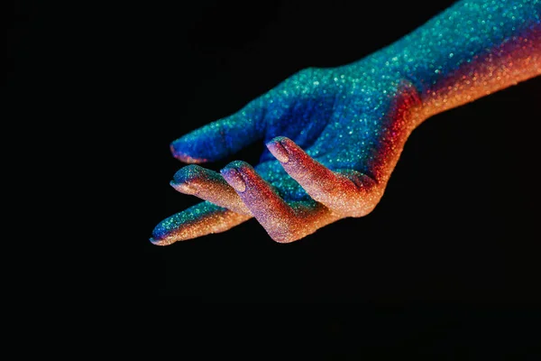 Γυναικείο χέρι καλυμμένο με ολογραφικό λαμπερό γκλίτερ κάτω από νέον χρωματιστό φως. Σώμα τέχνης, λαμπερό εννοιολογικό, στυλ μόδας. — Φωτογραφία Αρχείου