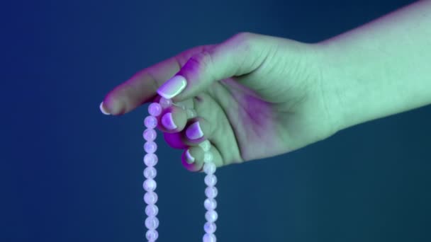 Donna che prega e tiene in mano le perle di mala per i conteggi durante le meditazioni mantra. Signora su sfondo blu. Spiritualità, religione, concetto di Dio. — Video Stock