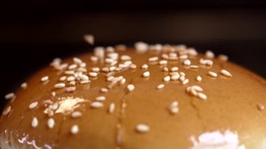 Kızarmış susam tohumları taze çöreğin üzerine serpilmiş, yakın çekim görüntüsü. Lezzetli hamburger, fast food konsepti..