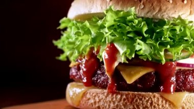 Dumanlı lezzetli burger, fast food konsepti. Et köftesi, domates, salatalık, marul, soğan ve susamlı taze ev yapımı ızgara hamburger. Sağlıksız bir yaşam tarzı. Yemek arkaplanı. Dolly vurdu.