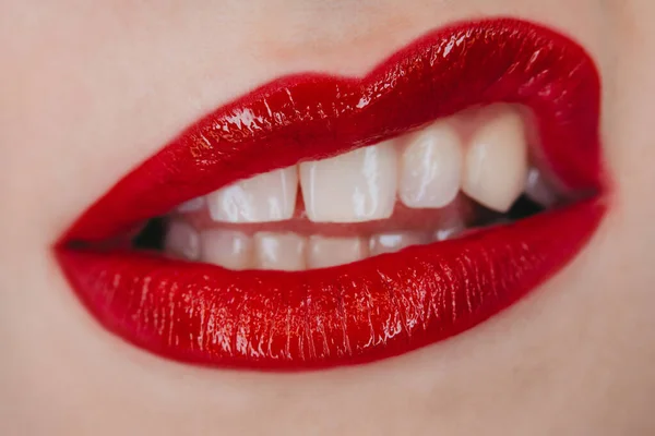 Displeased angry mouth gesture. Woman grimacing with glowing red lipstick. Macro view of glamorous make-up. .
