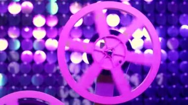 Renkli, parıldayan duvarda dönen bir film makarası. Eski moda 8 mm film projektörü sim odasında oynuyor. Eski nesneler, Oscar, sinema, Hollywood konsepti