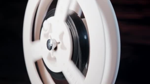 Retro old-fashioned 8mm projetor de filme jogando no quarto escuro. Close-up de bobina com filme girando. Objetos vintage, conceito de cinematografia — Vídeo de Stock