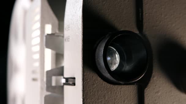 Vue de face du projecteur de film 8mm à l'ancienne, lampe clignote. Rayon de lumière projeté. Home cinéma, diffusion de films, bobines avec rotation de film — Video