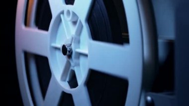 Film makarası dönüyor. Analog oynatıcı. Eski moda 8 mm 'lik projektör ev sinemasında film oynuyor. Eski nesneler, sinema, eğlence, nostalji konsepti