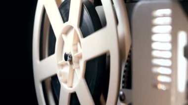 Bobbin film dönüşüm görüntüsü. Analog oynatıcı. Eski moda 8 mm 'lik projektör ev sinemasında film oynuyor. Klasik nesneler, festival ekran koruyucusu ve yayın ekipmanları için mükemmel.