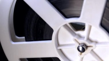 Bantla çevrilmiş bobinlerin görüntüsü. Analog oynatıcı. Tiyatroda eski moda 8 mm 'lik projektör oynuyor. Eğlence, nostalji, festival, yayın ekipmanları. Dolly vurdu.