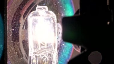 8mm 'lik film projektörü ampulü. Flaşlı ışıklar farklı ritimlerle yanıp sönüyor. Spot ışığı. Işık saçan halojen lamba. Nostalji, festival ekipmanları, yayın konsepti