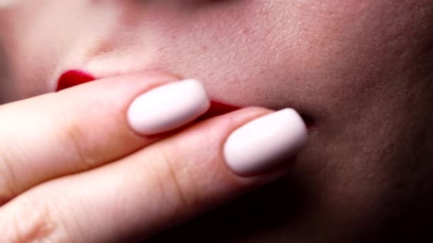 Close-up, mulher esfrega batom com dedos de lábios brilhantes vermelhos. Maquiagem borrada como protesto, insatisfação, arrependimento. Produto cosmético de beleza — Vídeo de Stock