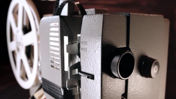 Gammaldags 8 mm filmprojektor som demonstrerar bandfilm. Projekterar ljusstråle. Hemmabio, radio, roterande spolar. Underhållning, nostalgi, festivalutrustning koncept — Stockvideo