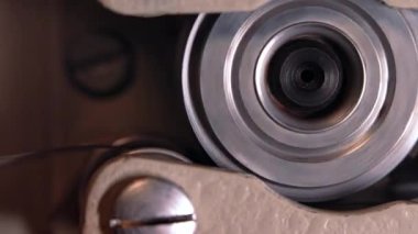 Çalışma sürecinin yakın plan detaylı görüntüsü eski moda 8mm projektör kaset filmiyle makara oynuyor. Bobin dönüyor. Eski nesneler, eğlence, nostalji, festival ekipmanları