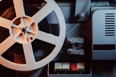 Bantlı bobinler dönüyor. Analog oynatıcı. Tiyatroda eski moda 8 mm 'lik projektör oynuyor. Eğlence, nostalji, festival, yayın ekipmanları.