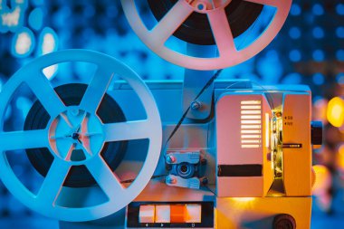 Pullar üzerinde dönen film makarası kinetik duvar, renkli ışık. Dekorasyon odasında eski moda 8 mm 'lik projektör. Klasik film nesneleri, sinema, Hollywood konsepti