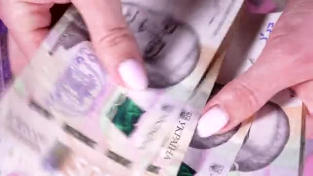 Vrouw telt UAH cash hryvnia 's op stapel geld achtergrond. Persoon telt winnende loterij, opbrengst van koopje. Nieuwe bankbiljetten in handen. — Stockvideo