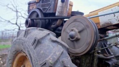 Makarayı kemerle döndürme işlemi. Adam bahçede motorlu birim motoblock ile çalışıyor. Küçük ölçekli bir traktör.. 
