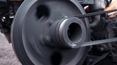 Makarayı kemerle döndürme işlemi. Adam bahçede motorlu birim motoblock ile çalışıyor. Küçük ölçekli bir traktör.. 