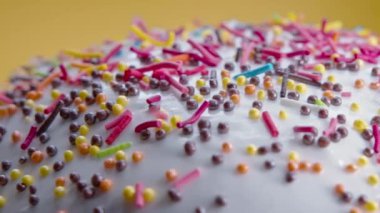 Sarı stüdyo arka planında renkli dekoratif serpiştirilmiş Paskalya pastası süslemesi. Ev yapımı pasta, Hıristiyan şenlik pastanesi, gelenek. Bahar dini bayramı 