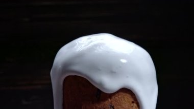 Dönüşümlü Paskalya pastası, beyaz jöleli dekorasyon ve renkli şeker serpiştirme, geleneksel fırın. Bahar Hıristiyan dini bayramı. Lezzetli ev yapımı şenlikli tatlılar. Siyah arkaplan.