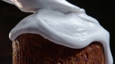 Paskalya pastasını beyaz jöleli geleneksel fırınla süsleme süreci. Bahar Hıristiyan dini bayramı. Lezzetli ev yapımı şenlikli tatlılar. Siyah arkaplan.