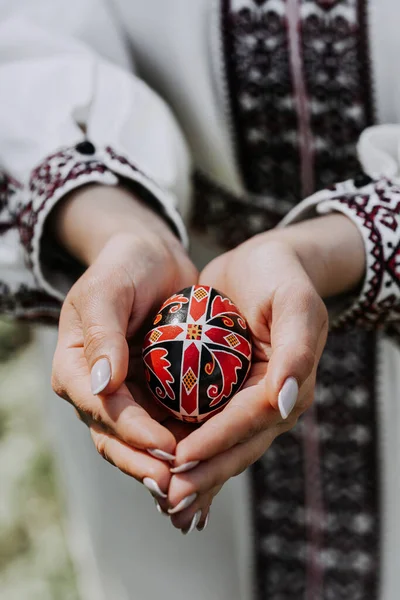 Mulher ucraniana de mãos dadas ovo de Páscoa. Bela decoração eslava geométrica. Senhora em bordado vestido vyshyvanka. — Fotografia de Stock
