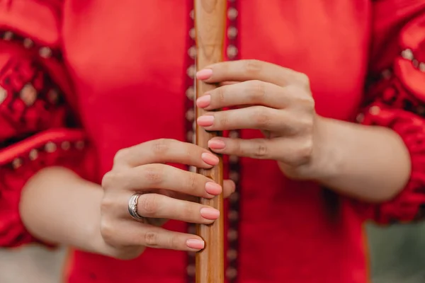 Mulher tocando flauta de madeira de vento - sopilka ucraniano ao ar livre. Conceito de música popular. Instrumento musical. Senhora na camisa bordada tradicional - Vyshyvanka vermelho. — Fotografia de Stock