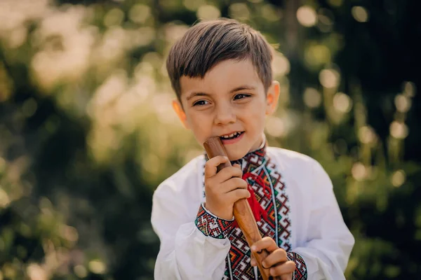 Portret chłopca z drewnianym fletem - ukraińska sopilka. Koncepcja muzyki ludowej. Instrumenty muzyczne. Dziecko w tradycyjnej koszuli haftowanej - Vyshyvanka. — Zdjęcie stockowe