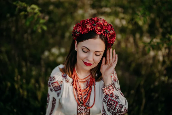 Mulher ucraniana atraente em vestido tradicional bordado vyshyvanka, contas de coral antigas e grinalda de flores vermelhas. Ucrânia, liberdade, cultura, traje nacional, vitória na guerra. — Fotografia de Stock