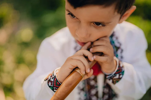 Portret chłopca z drewnianym fletem - ukraińska sopilka. Koncepcja muzyki ludowej. Instrumenty muzyczne. Dziecko w tradycyjnej koszuli haftowanej - Vyshyvanka. — Zdjęcie stockowe