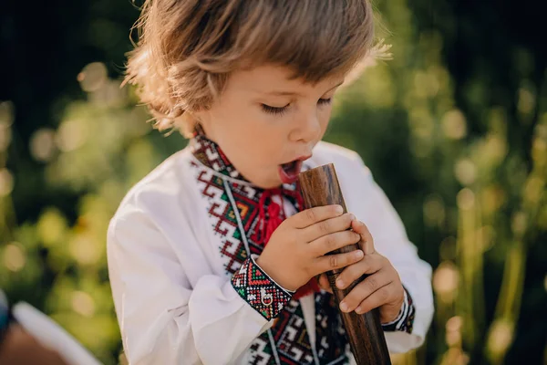 Portret chłopca z drewnianym fletem - ukraińska sopilka. Koncepcja muzyki ludowej. Instrumenty muzyczne. Dziecko w tradycyjnej koszuli haftowanej - Vyshyvanka. — Zdjęcie stockowe