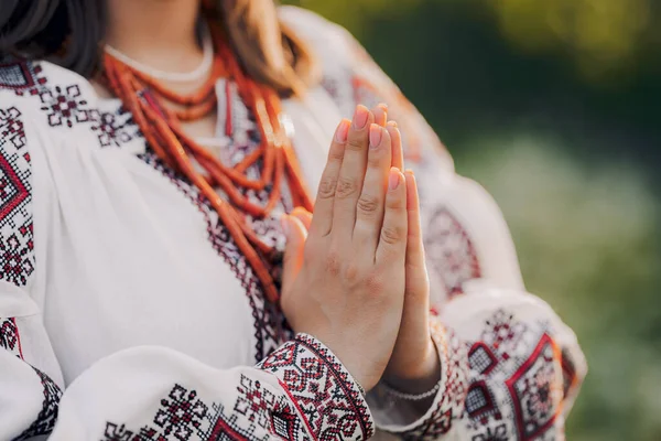 Priez pour l'Ukraine, restez avec nous. Femme ukrainienne en broderie traditionnelle vyshyvanka robe tenant la main dans le geste de prière - anjali mudra. — Photo