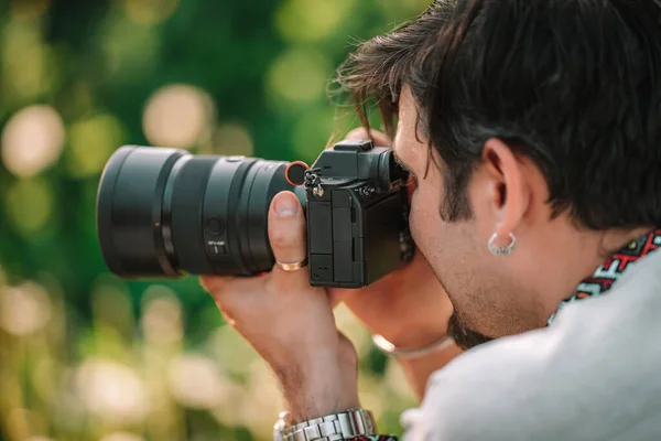 Фотограф-чоловік фотографує професійну цифрову камеру на відкритому повітрі. Cameraman, що працює з DSLR обладнанням. — стокове фото