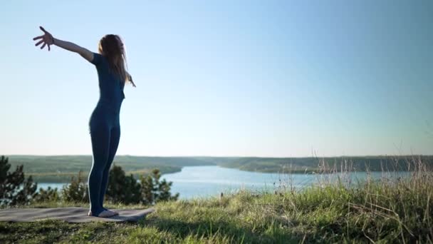 Mujer yogui que comienza la práctica de yoga con respiración profunda en sitio abierto de alta montaña. Naturaleza salvaje, humano libre. Libertad, práctica, logro de metas — Vídeo de stock