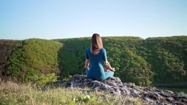 Tenang damai yogi wanita duduk di teratai sambil bermeditasi, merasa bebas di depan alam liar. Pelatih kebugaran pikiran memiliki momen zen. Latihan yoga sehari-hari, nafas yang tenang, konsep konsentrasi — Stok Video