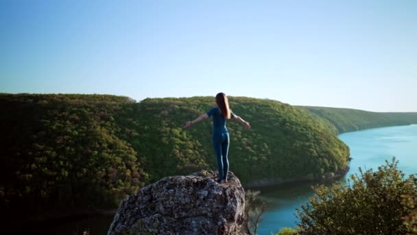 Yogi kvinna når toppen av sten på högt berg och börjar yoga praktiken med djup andning. Vild natur, fri människa. Frihet, praktik, uppnådda mål — Stockvideo