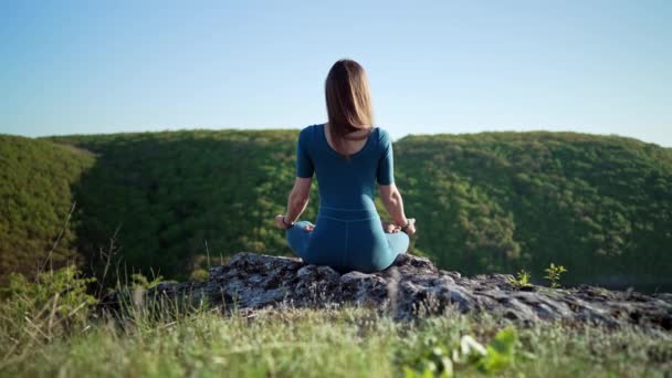 Mujer yogui tranquila relajada sentada en loto mientras medita, sintiéndose libre frente a la naturaleza salvaje. Entrenador de fitness consciente de tener momento zen. Práctica diaria de yoga, respiración tranquila, concepto de concentración — Vídeos de Stock