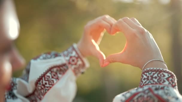 Ukrainian woman in traditional embroidery vyshyvanka dress making sign of shape heart. Ukraine, volunteering, donation help and love concept. — Stock Video