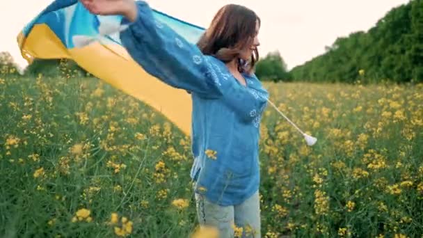 Kanola Çiçekli Çayır Arka Planında Ulusal Bayrağı Olan Mutlu Ukraynalı — Stok video