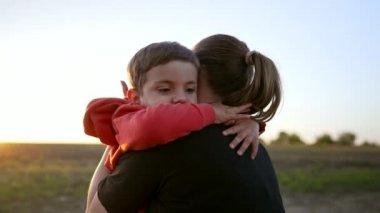Sevgi dolu gülümseyen oğul annesine sıkıca sarılır. Hassas aile sahnesi. Annesi olan sevimli Ukraynalı 3 yaşında bir çocuk. Ebeveynlik, çocukluk, mutluluk, çocukların refahı kavramı. Yüksek kalite 4k görüntü