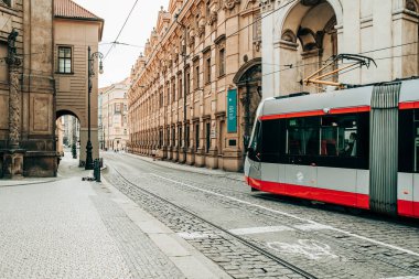 Prague, Czech Republic - July 2022. Modern tram on beautiful cozy street in old town. Urban public transport. Amazing european architecture, historical facades of traditional buildings. High quality