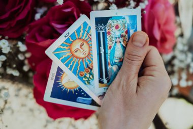 Falcı elinde çiçek arkaplanındaki kahin kartlarını tutuyor. Tarot okuyucu. Gelecek tahmini, ezoterik, sezgi konsepti. Yüksek kalite fotoğraf