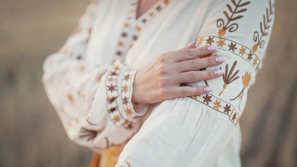 Ukrainian woman showing embroidery ornament, beautiful details of vyshyvanka shirt. National costume - embroidered shirt, texture, design, folk, handmade craft needlework. High quality photo
