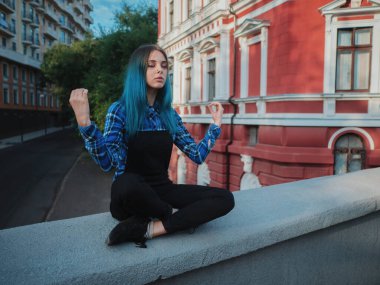 Sakin sokak serseri veya hippi kız mavi boyalı saçlı. Burun, Avrupa boş sokakta meditasyon sıradışı saç modeli olarak Delme ile bir kadın. Yoga kavramı.