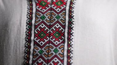 Man demonstrating geometric details of embroidery ornament on vyshyvanka shirt. National costume - embroidered shirt, texture, design, folk, handmade craft needlework. High quality 4k footage