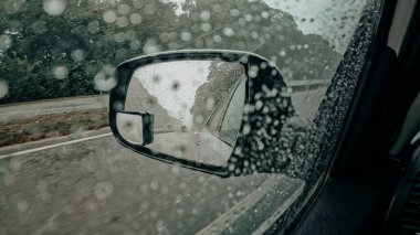 Yağmur damlacıkları olan yan sürücüler araba aynası. Yağmurlu bir havada, yoğun bir yolda otomobil kullanmak. Otoban yolculuğu. Yüksek kalite 