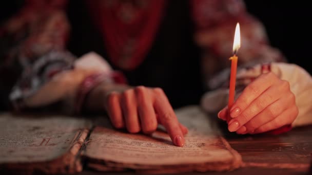 读古籍的乌克兰女人 聚精会神地在烛光下紧随纸页上的手指 基辅罗斯的历史 19世纪 祈祷和诗篇 高4K镜头 — 图库视频影像