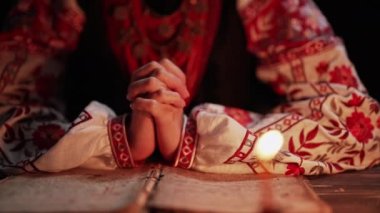 Eski kitapları okuyan Ukraynalı bir kadın. Kutsal İncil ve dua. Ukrayna 'nın geleneksel otantik kostümlü kadını. Christian kutsal kitap okuyor. Öğrenme, minnettarlık, din kavramı. Yüksek kalite 4k görüntü.