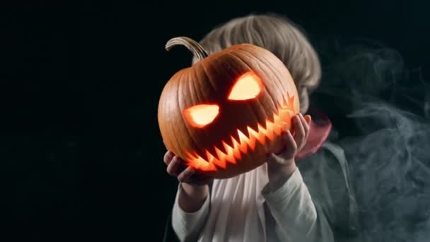 Filho Adorável Traje Vampiro Segurando Abóbora Esculpida Fundo Preto Halloween — Vídeo de Stock
